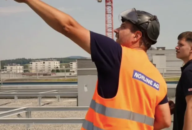 Zwei Monteure auf dem Dach während der Kranmontage