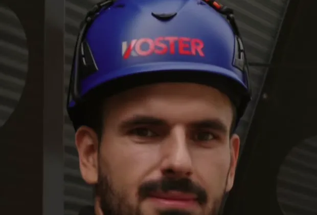 Monteur der Koster AG mit Helm auf der Baustelle